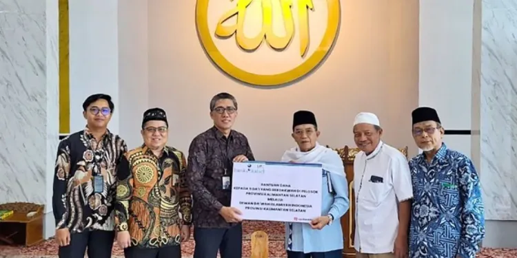 Dirut Bank Kalsel Fachrudin saat menyerahkan bantuan untuk sembilan Dai DDII Kalsel. (foto : istimewa)