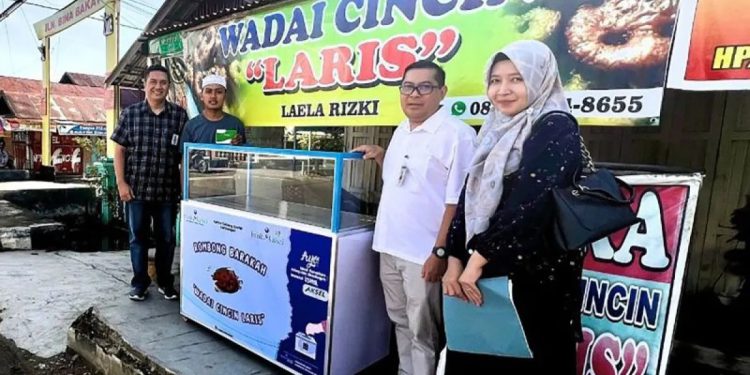 Kepala Kantor Cabang Syariah Kandangan M Fadjrin secara simbolis menyerahkan dua unit rombong barakah, kepada dua pelaku UMKM. (foto : istimewa)