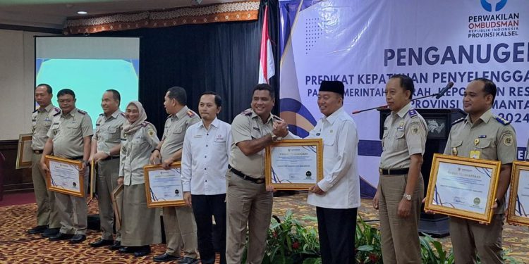 Plt Gubernur Kalsel H Muhidin serahkan penghargaan dari Perwakilan Ombudsman RI Kalsel kepada Kepala Kantor Pertanahan Banjarbaru Dr Ahmad Suhaimi. (foto : istimewa)