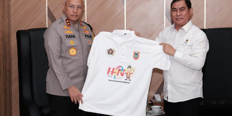 Ketua PWI Kalsel Zainal Helmie saat memberikan baju HPN 2025 kepada Kapolda Kalsel Irjen Pol Rosyanto Yudha Hermawan. (foto : istimewa)