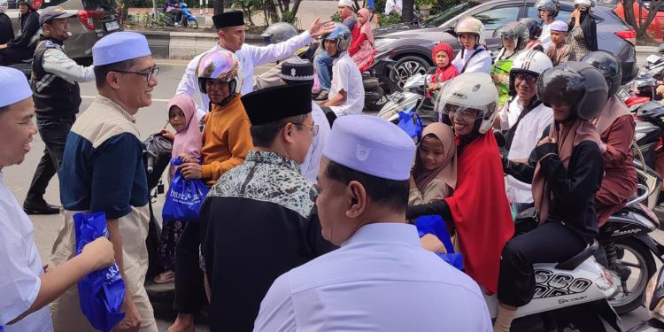 Dirut Bank Kalsel Fachrudin bersama Walikota Banjarmasin H Ibnu Sina saat membagikan konsumsi gratis kepada jemaah haul Guru Sekumpul. (foto : Bank Kalsel)