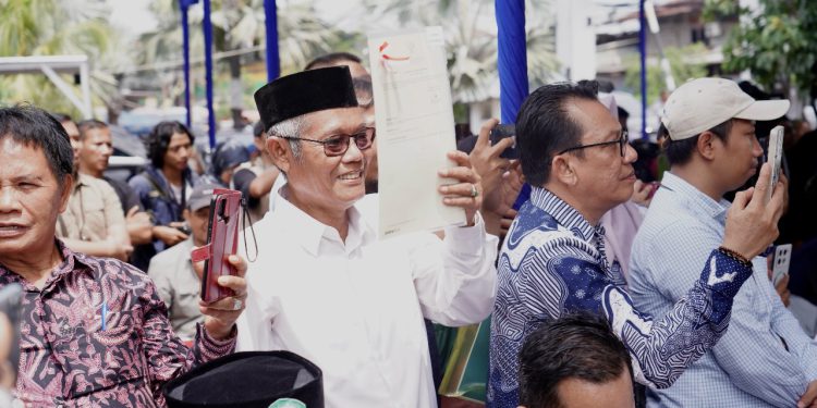 Hasyim, warga Kampung  Nelayan saat menunjukkan sertipikat HGB yang diserahkan Menteri Nusron Wahid. (foto : istimewa)