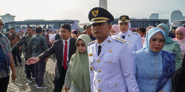 Walikota Banjarmasin HM Yamin saat menggandeng tangan sang ibu dan istri saat menuju pelantikan. (foto : istimewa)