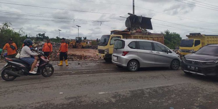 Petugas kebersihan saat membersihkan sampah di TPS Ilegal yang kini ditutup dan dipasangi CCTV. (foto : shn/seputaran)