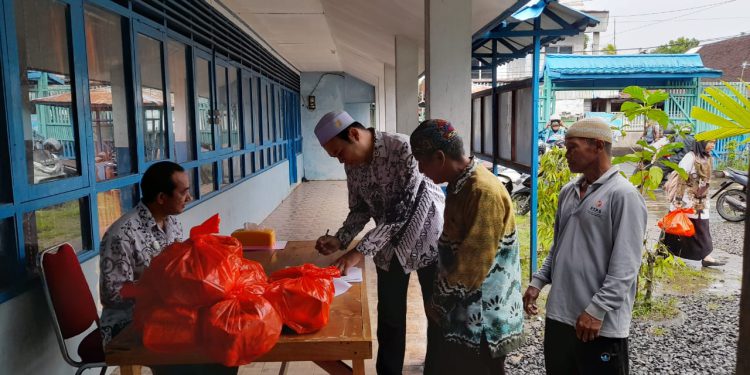 Para guru saat mengambil paket sembako yang dibagikan PGRI Banjarmasin Selatan. (foto : shn/seputaran)