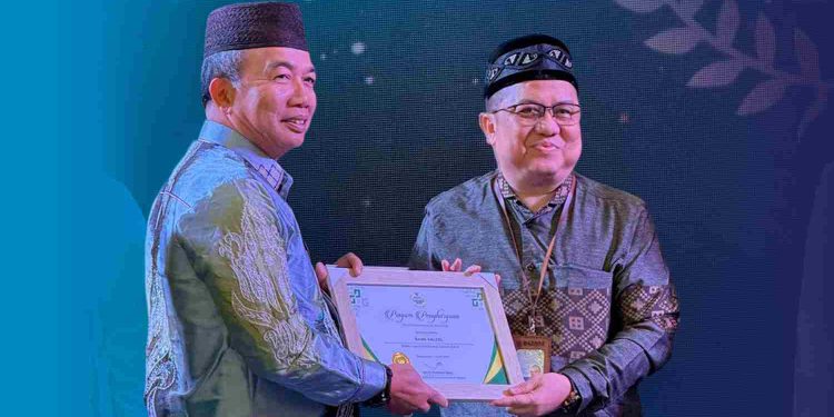 Penghargaan diserahkan Pj Sekdaprov Kalsel M Syarifuddin kepada Direktur UPZ Bank Kalsel Fajri Muhtadi. (foto : Bank Kalsel)