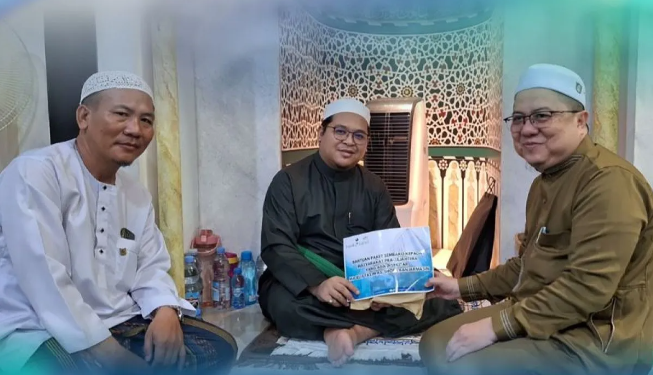 Direktur UPZ Bank Kalsel HM Fajri Muhtadi menyerahkan bantuan paket sembako kepada pimpinan Majelis As Shofa Banjarmasin Ustadz H Ilham Humaidi. (foto : bank Kalsel)