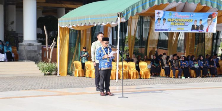 Bupati Tapin H Yamani saat memberikan sambutan pada peringatan Hardiknas. (foto : istimewa)