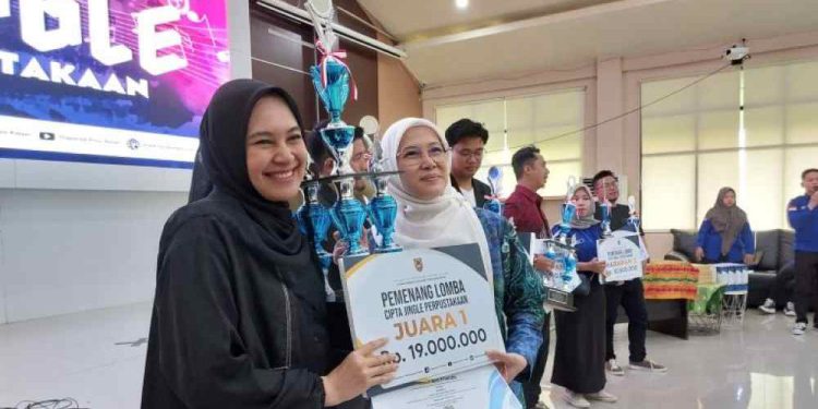 Plt Kepala Dispersip Kalsel Adethia Hailina saat serahkan tropi untuk pemenang Lomba Cipta Jingle. (foto : istimewa)