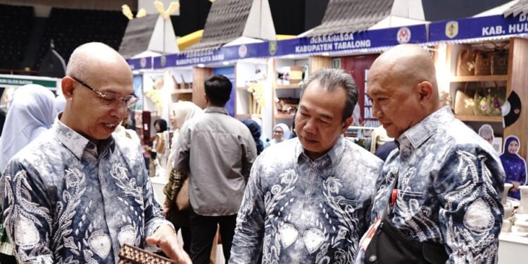 Pj Bupati Tapin Muhammad Syarifuddin, Sekretaris Daerah Sufiansyah dan Kadis Perindustrian, Yustan Azidin melihat kerajinan yang ditampilkan Dekranasda di Inacraft 2025. (foto : istimewa)