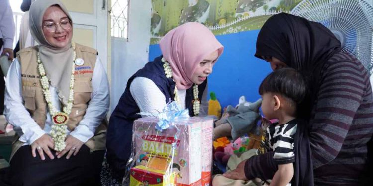 Wakil Ketua Tim Pembina Kalsel drg Ellyana Trisya Hasnuryadi didampingi Ketua Tim Pembina Posyandu Kalsel Hj Nelly Listriani Yamin saat memberikan layanan kesehatan untuk anak di Posyandu Lestari. (foto : shn/seputaran)