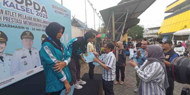 Wagub Kalsel H Hasnuryadi Sulaiman saat pengalungan medali kepada atlet yang juara di salah satu cabor Popda Kalsel. (foto : istimewa)