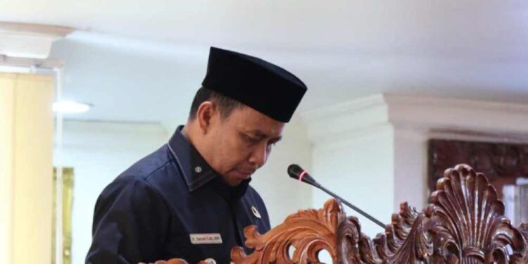 Bupati Tapin H Yamani membacakan pengantar Raperda Pertanggungjawaban Pelaksanaan APBD 2024 pada rapat paripurna DPRD Tapin. (foto : istimewa)