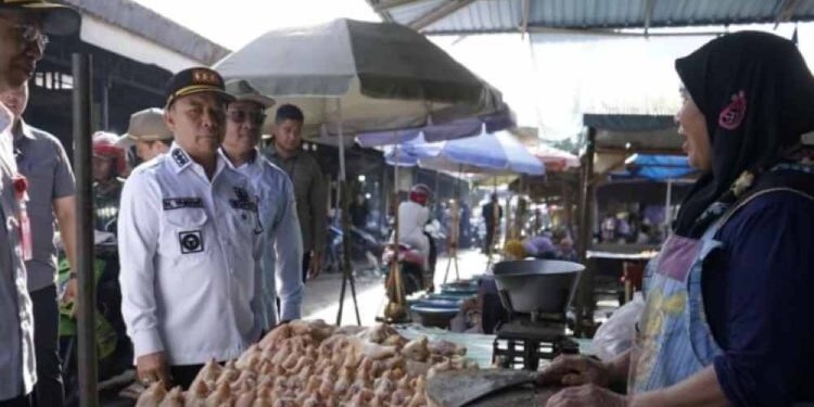 Bupati Tapin H Yamani saat monitoring stok dan harga kebutuhan pokok di pasar induk Keraton Raya Rantau. (foto : istimewa)