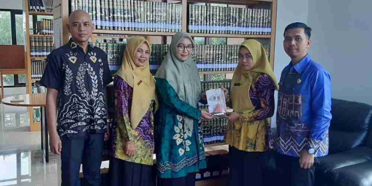 Pihak Bidang Pengelolaan Koleksi Bahan Perpustakaan Dispersip Kalsel serahkan plakat ke pihak Dispersip Kotabaru saat   hunting karya lokal. (foto : istimewa)