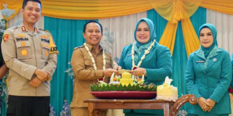 Bupati Tapin H Yamani saat serahkan  potongan nasi tumpeng kepada Ketua TP PKK Tapin Hj Faridah Yamani pada Puncak peringatan HKG PKK ke-53 dan Harganas ke-32 di Pendopo Galuh Bastari. (foto : Prokopim Tapin)