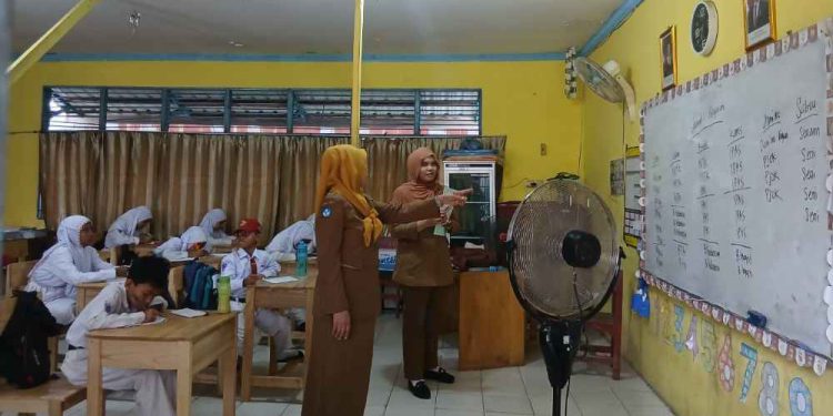 Guru SDN Kelayan 2 Banjarmasin saat memberikan pengajaran kepada sembilan murid tahun ajaran baru. (foto : shn/seputaran)