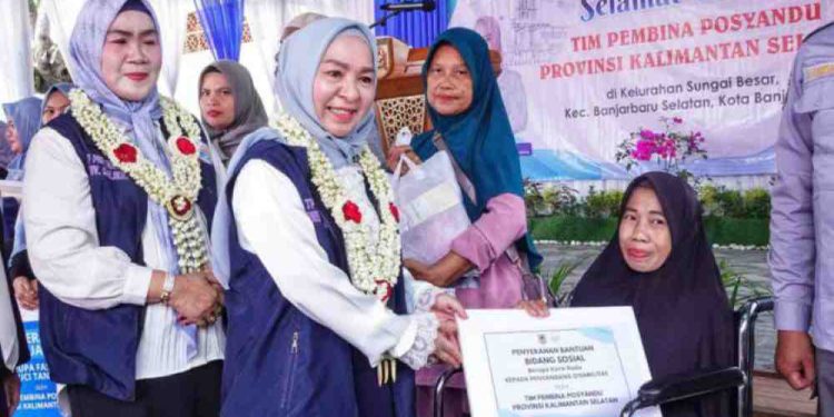 Ketua TP Posyandu Kalsel, Hj Fathul Jannah Muhidin menyerahkan bantuan kursi roda untuk penyandang disabilitas di Posyandu Permata, Banjarbaru. (foto : istimewa)