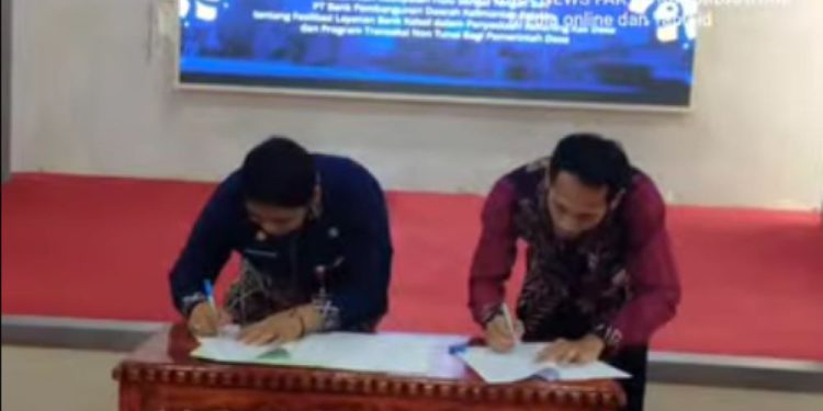 Plt Kepala Cabang Bank Kalsel Rabbiyanur Fahmi dan Kepala Dinas PMD HST Edy Rahmawan saat tanda tangan kerja sama transaksi non tunai. (foto : Istimewa)