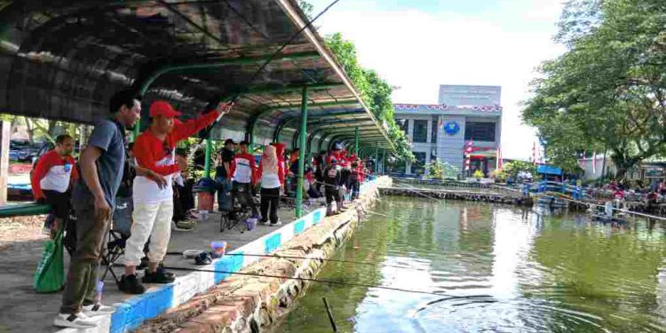 Kepala BP2TPM Banjarmasin Ariyani saat menarik ikan yang didapat pada lomba mancing. (foto : shn/seputaran)