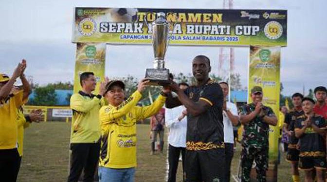Bupati Tapin H Yamani saat menyerahkan pilaa kepada tim pemenang Turnamen Sepak Bola Bupati Cup 2025. (foto : istimewa)