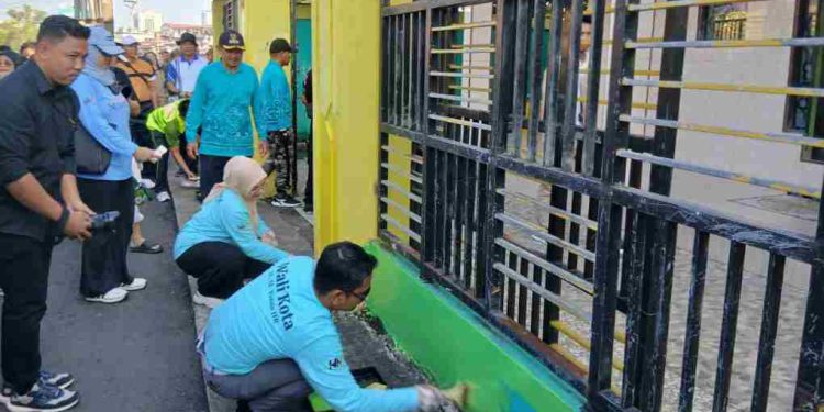 Walilkota Banjarmasin HM Yamin bersama istri Hj Neli Listriani saat mengecat pagar fasilitas umum di Taluk Kelayan. (foto " shn/seputaran)
