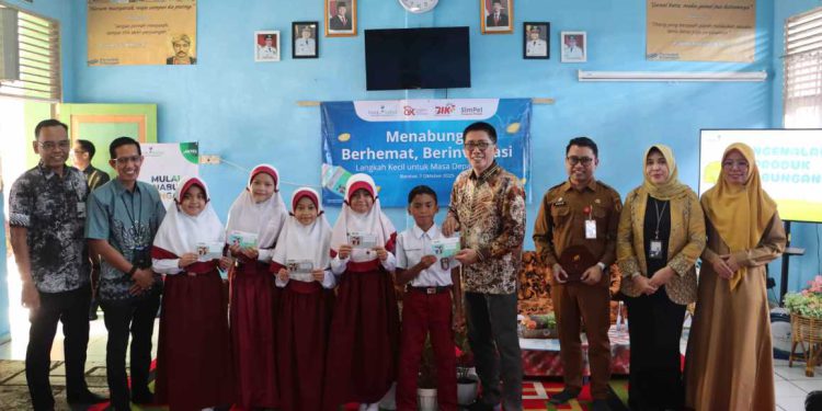 Direktur Utama Bank Kalsel Fachrudin saat menyerahkan buku tabungan pada kegiatan edukasi keuangan di SDN 1 Barabai Timur. (foto : Bank Kalsel)