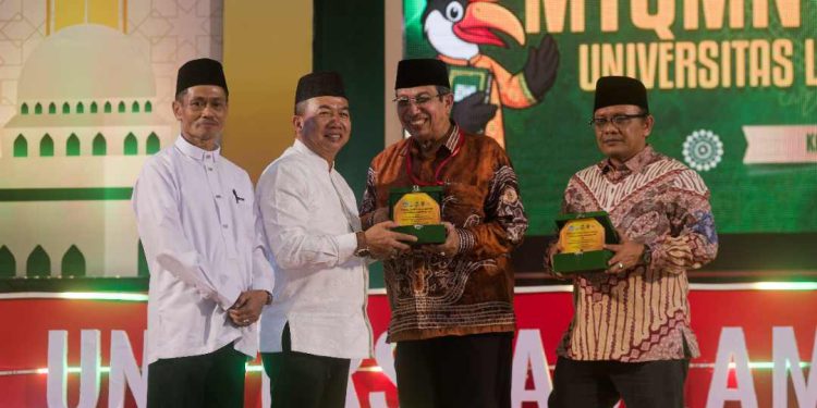 Sekretaris Daerah Provinsi Kalsel H Muhammad Syarifuddin saat serahkan cendera mata pada malam penutupan MTQMN ke - XVIII 2025. (foto : Adpim Kalsel)