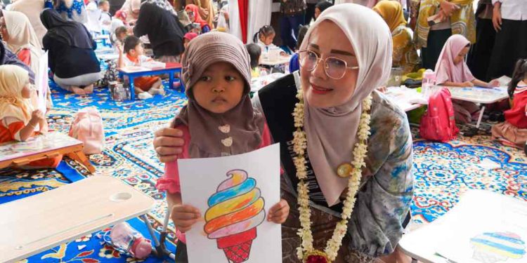 Bunda PAUD Banjarmasin Neli Listriani saat berfoto dengan salah satu anak PAUD. (foto : shn/seputaran)