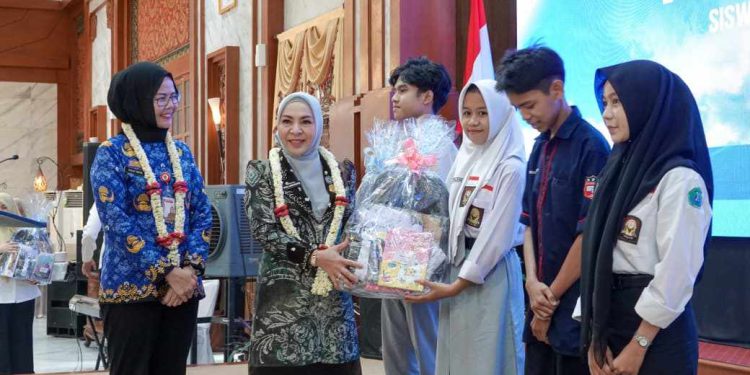 Ketua TP PKK Kalsel Hj Fathul Jannah Muhidin menyerahkan BSKM kepada perwakilan pelajar. (foto : Adpim Kalsel)