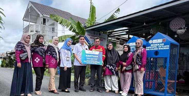 Penyerahan bantuan oleh Kepala Bagian Inklusi Literasi dan Tanggung Jawab Sosial Kemasyarakatan, Fandry Azhari kepada Kepala PDU Skala RT Bank Sampah “Bahe ‘Mart”, Istiqomah. (foto : Bank Kalsel)