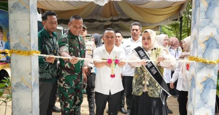 Bupati Tapin H Yamani bersama istri saat gunting pita peresmian gedung RBI di Desa Kambang Habang. (foto : istimewa)