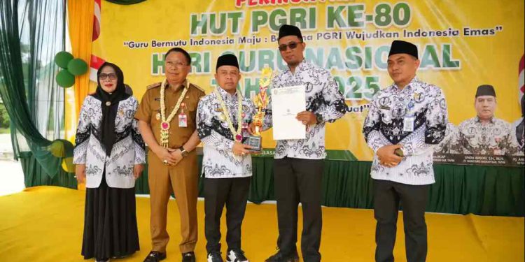 Bupati Tapin H Yamani saat menyerahkan penghragaan kepada guru purnatugas di peringatan HGN. (foto : istimewa)