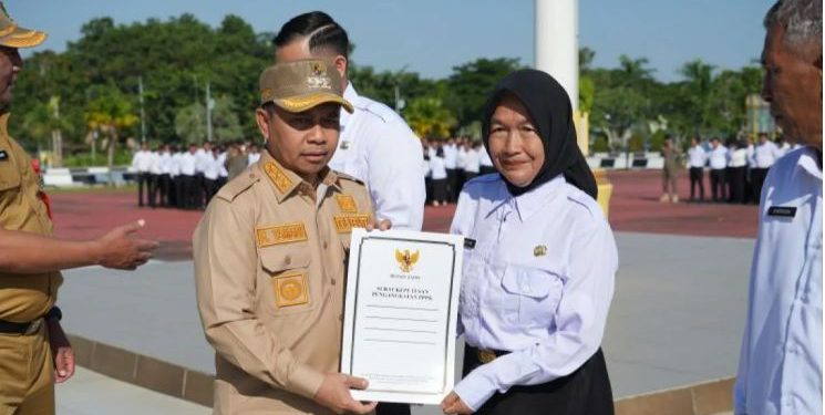 Bupati Tapin H Yamani saat menyerahkan SK Pengakatan kepada perwakilan PPPK Pemkab Tapin. (foto : istimewa)