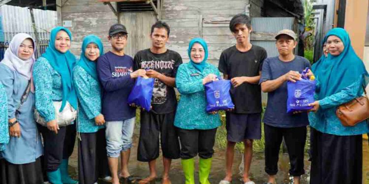 Ketua TP PKK Banjarmasin Neli Listriani dan anggota saat membagikan bantuan sembako dan obat-obatan untuk warga terdampak banjir. (foto : shn/seputaran)