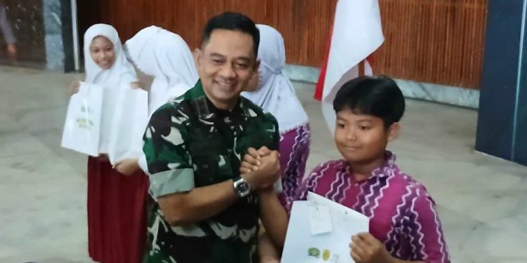 Danrem 101/Antasari Brigjen TNI Ilham Yunus saat membagikan sepasang sepatu kepada siswa sekolah. (foto : shn/seputaran)