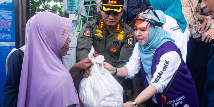 Ketua TP PKK Kalsel Hj Fathul Jannah Muhidin saat menyerahkan bantuan kepada warga terdampak banjir. (foto : Adpim Kalsel)