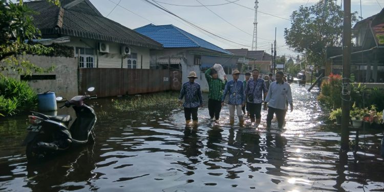 Pihak Kecamatan Banjarmasin Timur dan Keluharan Kuripan saat menyerahkan bantuan banjir untuk wilayah yang terdampak. (foto : shn/seputaran)