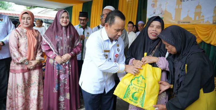 Bupati Tapin H Yamani saat menyerahkan bantuan kebutuhan pokok kepada warga kurang mampu. (foto : istimewa)