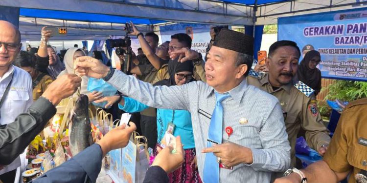 Sekdaprov Kalsel M Syarifuddin saat melayani warga yang membeli di GPM. (foto : adpim kalsel)