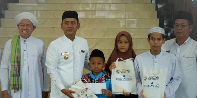 Walikota Banjarmasin HM Yamin saat menyerahkan bantuan sarung kepada anak panti asuhan. (foto : shn/seputaran)