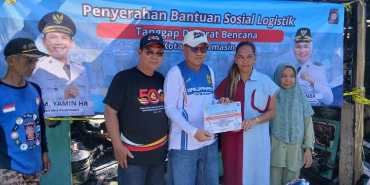 Penyerahan Bantuan oleh Asisten 1 Setdakot Banjarmasin Dr H Lukman Fadlun didampingi Kadinsos Banjarmasin Nuryadi kepada warga korban kebakaran. (foto : shn/seputaran)