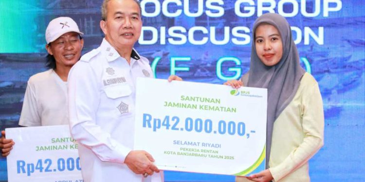 Sekdaprov Kalsel  H M Syarifuddin saat menyerahkan santuan jaminan kematian kepada penerima. (foto : adpim kalsel)