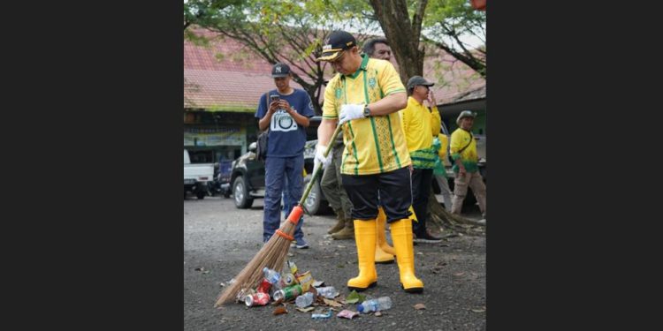 Bupati Tapin H Yamani menyapu di halaman pasar Keraton pada aksi Korvei dan Gerakan Asri. (foto : istimewa)