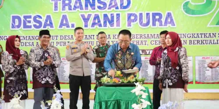 Wabup Tapin H Juanda potong tumpeng pada peringatan HUT ke-57 Desa A Yani Pura. (foto : istimewa)
