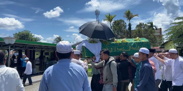 Para jemaah saat mengangkat keranda jenazah KH Husin Nafarin. (foto : shn/seputaran)