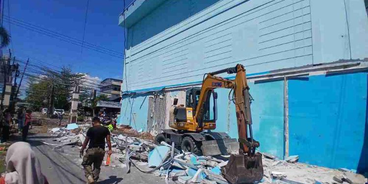 Ekskavator saat melakukan pembongkaran bangunan yang melanggar aturan. (foto : shn/seputaran)