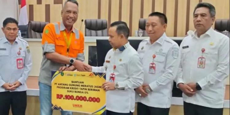 Bantuan secara simbolis diserahkan perwakilan PT AGM Imam Arifianto selaku Kepala Teknik Tambang (KTT) PT AGM kepada Bupati Tapin H Yamani. (foto : istimewa)
