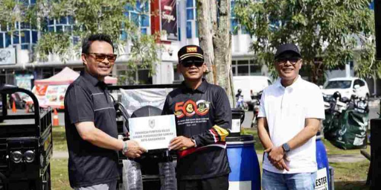 Plh Sekdaprov Kalsel Subhan Nor Yaumil secara simbolis menyerahkan bantuan fasilitas pengelolaan lingkungan kepada Walikota Banjarmasin HM Yamin. (foto : shn/seputaran)