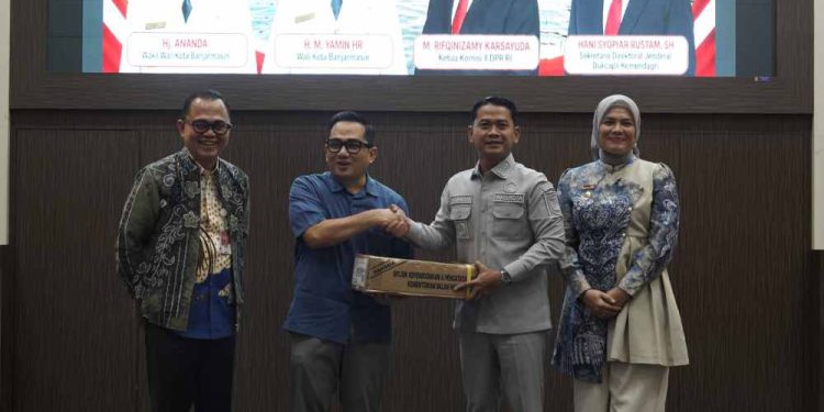 Walikota Banjarmasin HM Yamin didampingi Wakil Walikota Banjarmasin Hj Ananda menerima data kependudukan dari Ketua Komisi II DPR RI Rifqinizamy Karsayuda. (foto : shn/seputaran)